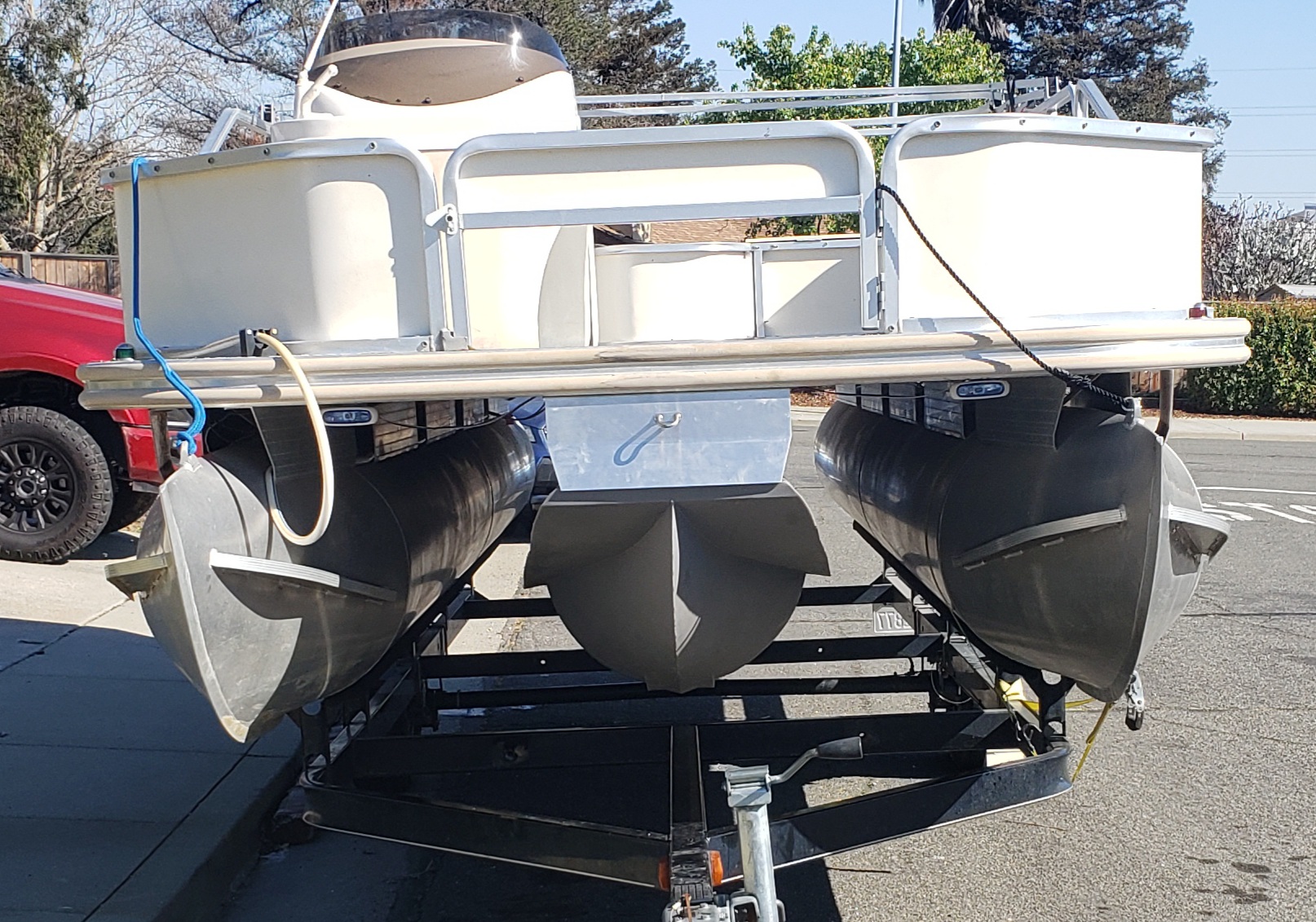 Front view of white pontoon with Poly3rdTube™ installed on trailer